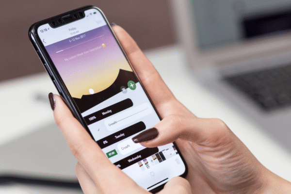 deux mains tenant un téléphone dont l'écran est allumé
